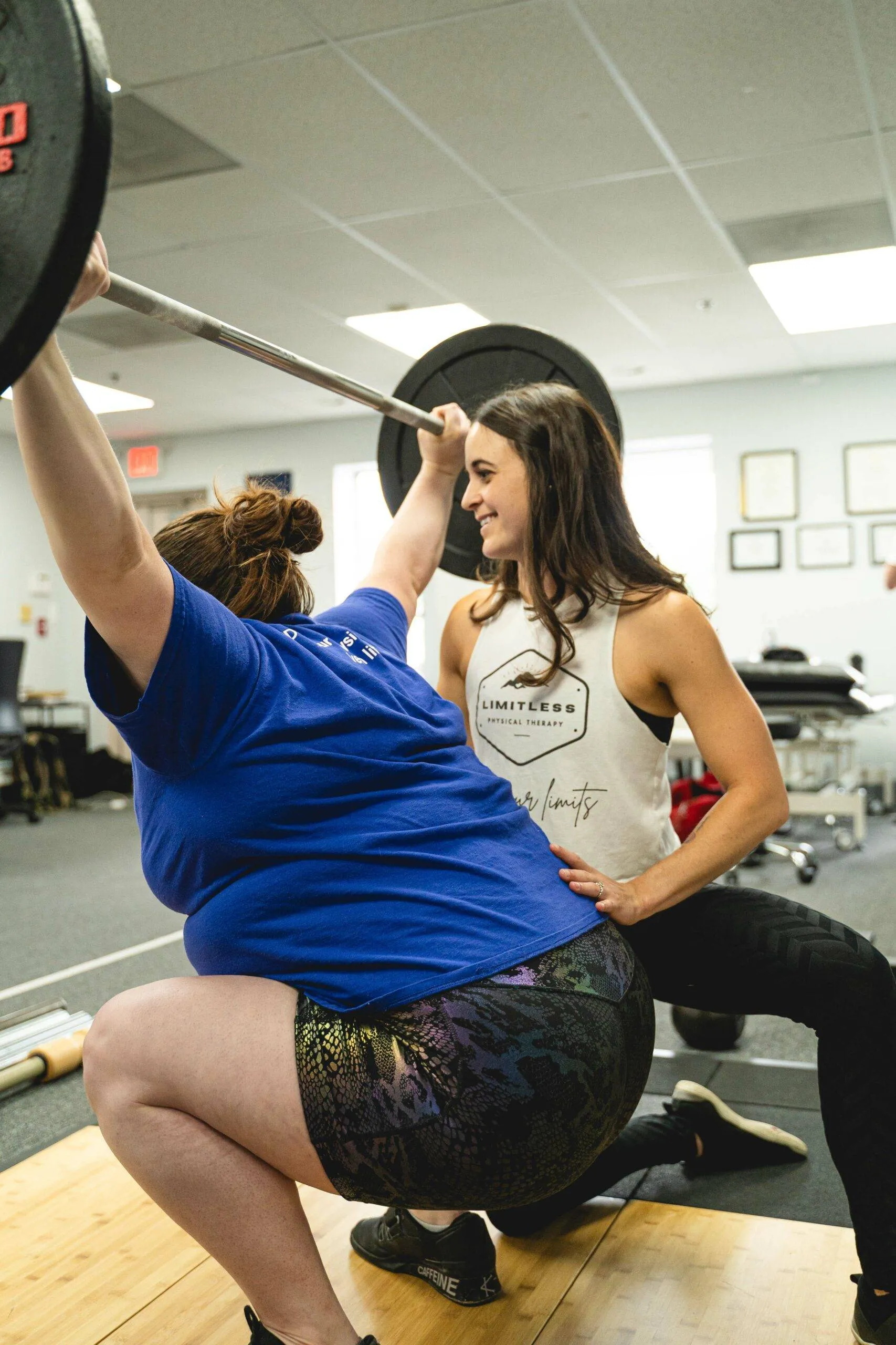 Barbell Rehab Sports Performance Physical Therapist, Christa, helping with a barbell snatch