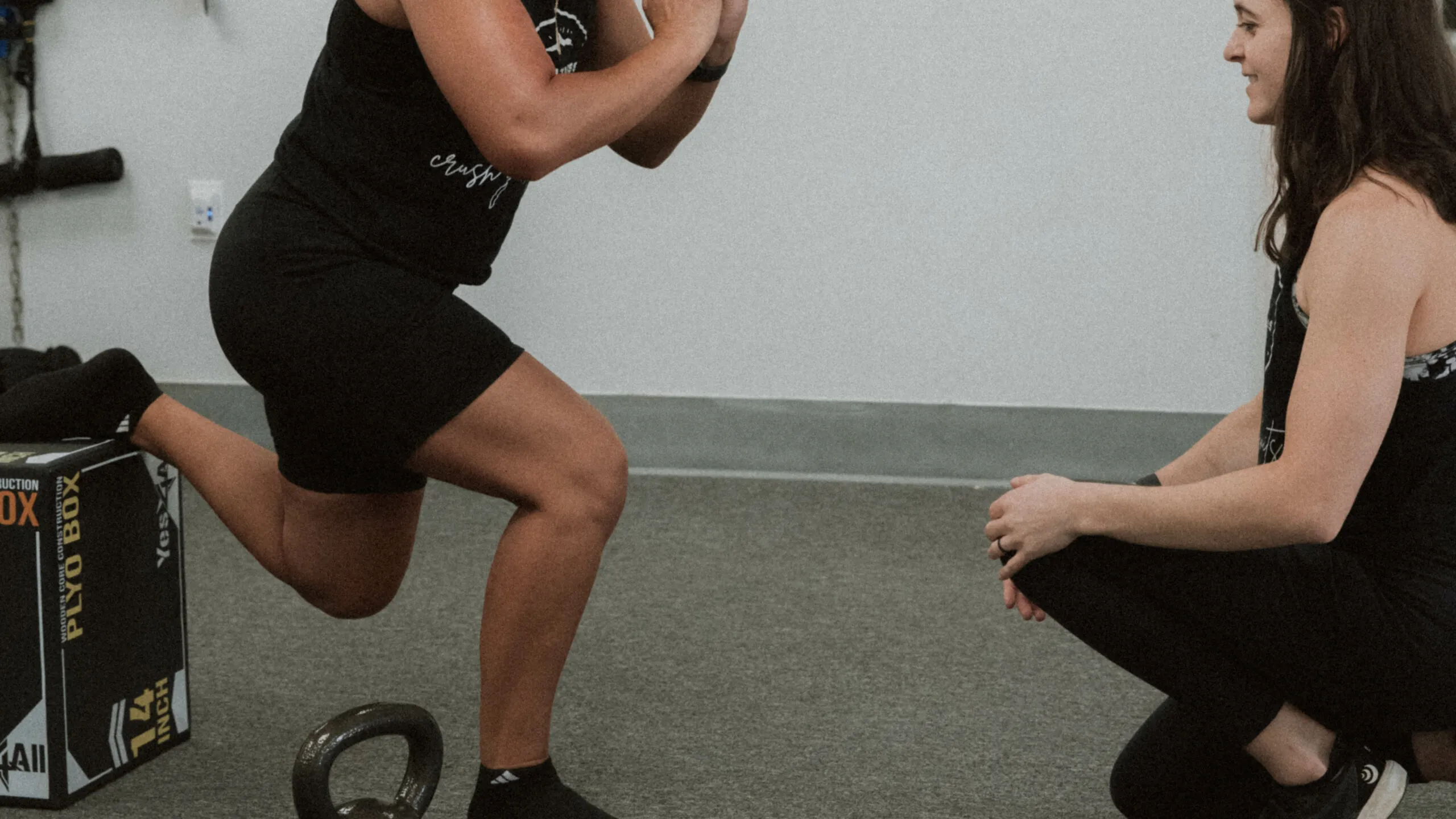 7D6A5102-2-scaled-1 Physical therapist helping a patient with knee pain do a squat